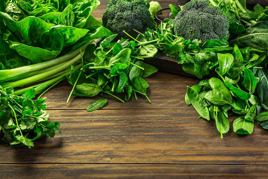 green organic vegetables and dark leafy food background as a hea